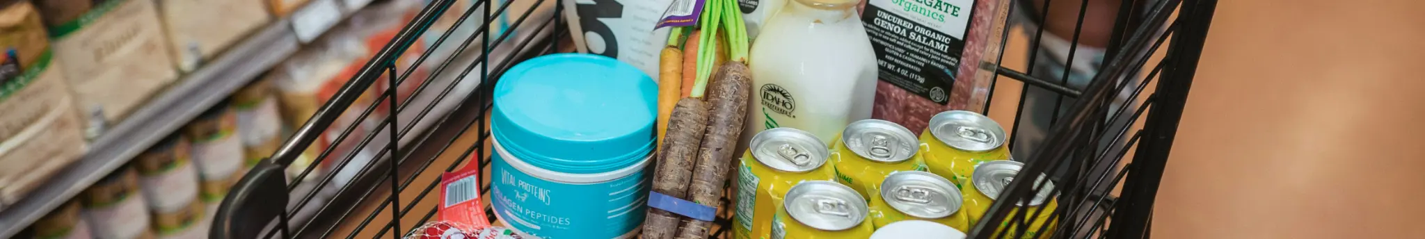 Winkelkar gevuld met boodschappen in de supermarkt voor een slim weekbudget.
