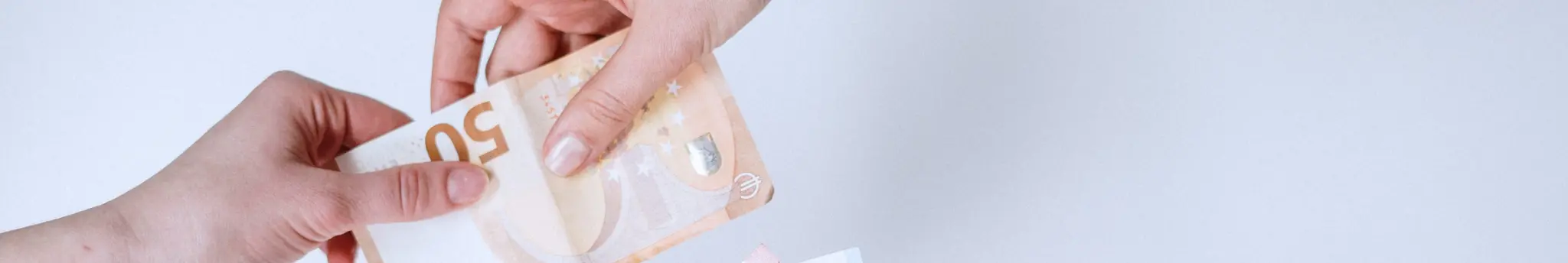 Handen wisselen een briefje van 50 euro uit als symbool voor geld besparen.